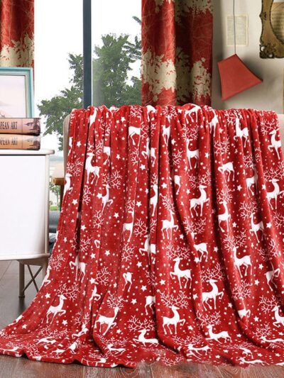 Couverture rouge et blanche de Noël posée sur un accoudoir de canapé.