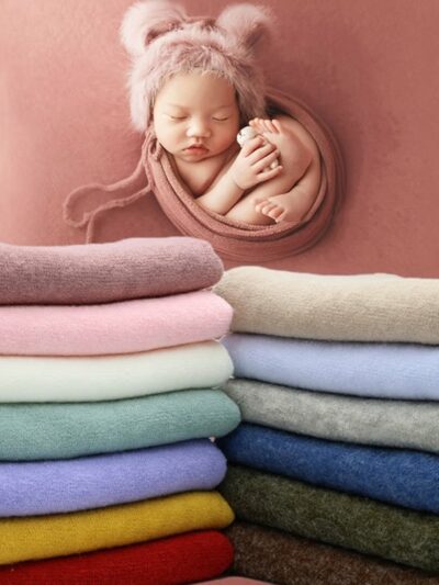 Couvertures d'emmaillotage colorées et empilées. Bébé emmailloté dans une couverture rose.