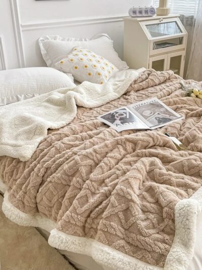 Lit avec une couverture en laine marron et blanche, chambre avec parquet, couleurs claires
