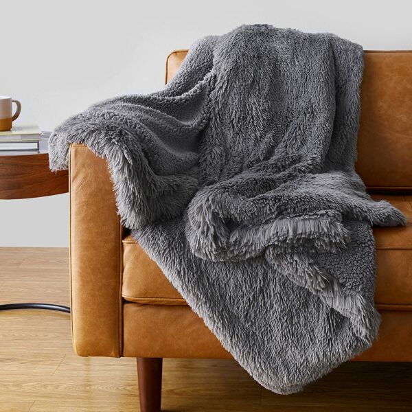 Canapé recouvert d'une couverture épaisse grise.