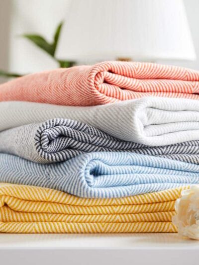 Photo de couvertures tricotés à chevrons coloré empilées.