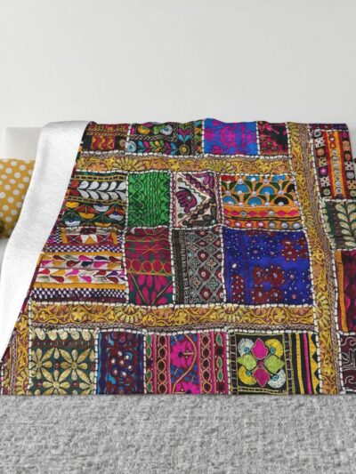 Photo d'une couverture imprimé patchwork style bohème sur un canapé.