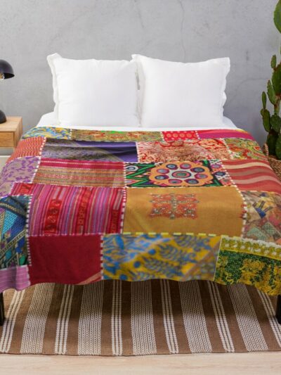 Photo d'une couverture imprimé patchwork multicolore sur un lit.