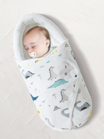 Bébé dormant dans une couverture d'emmaillotage, fond blanc.