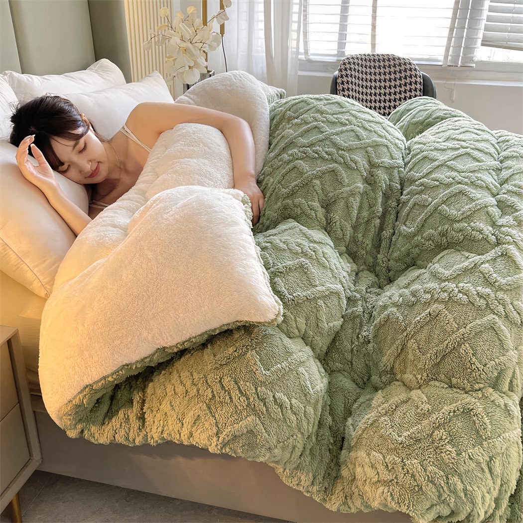 Femme dormant dans un lit avec une couverture épaisse verte.