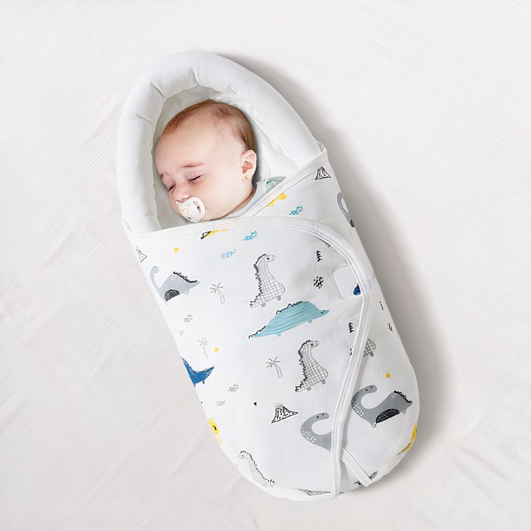 Bébé dormant dans une couverture d'emmaillotage, fond blanc.