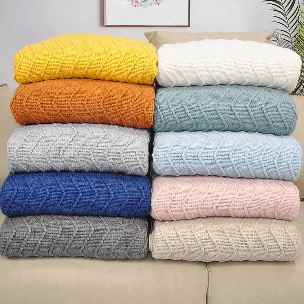 Photo de couverture tricoté avec motif de zigzag de toutes les couleurs pliées et empilées