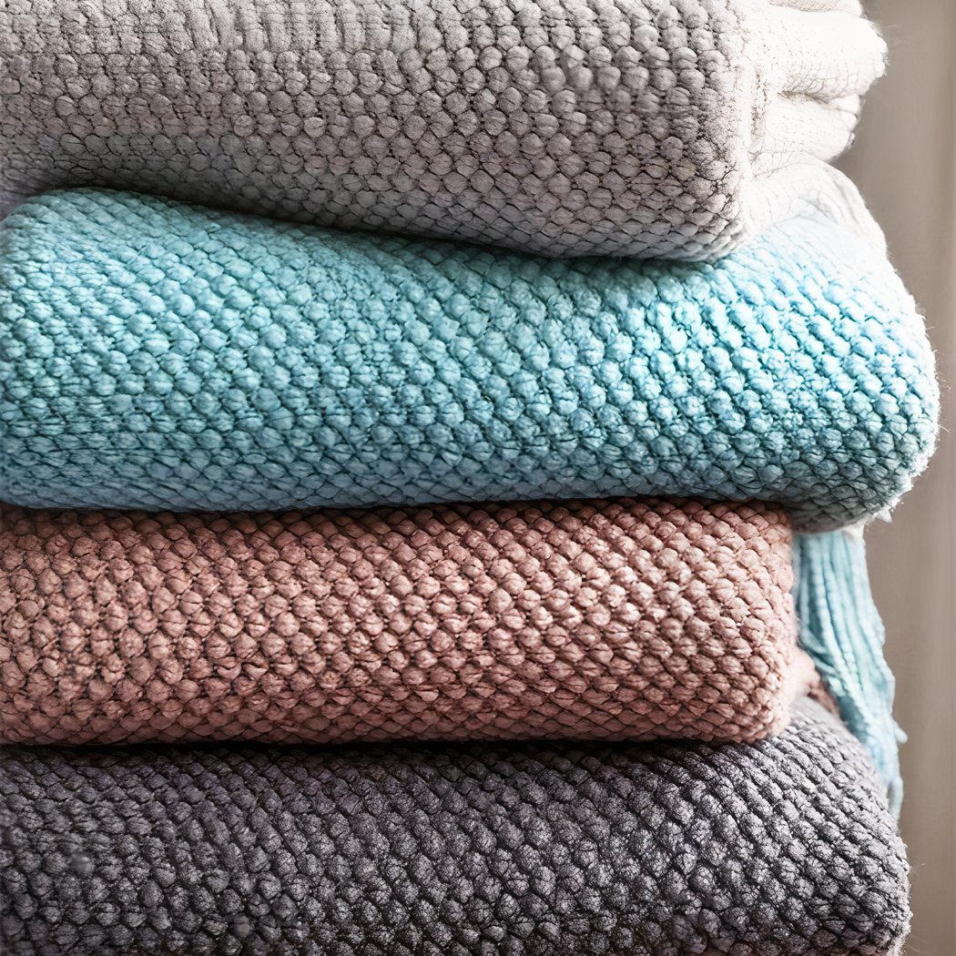 Photo de couvertures en tricot gaufrées pliées et empilées.