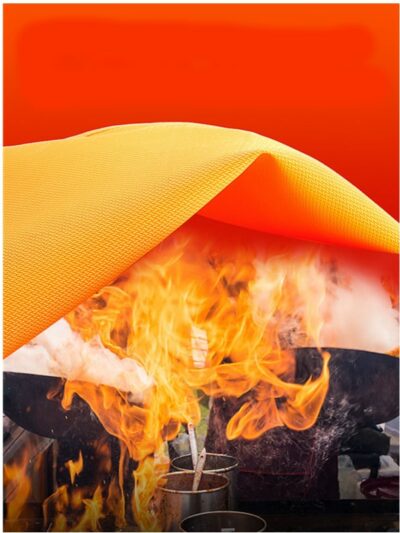 On voit une couverture anti-feu orange qui recouvre une cuisinière en feu.