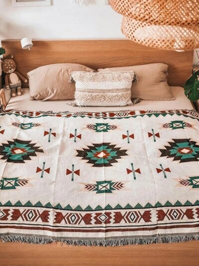 Photo d'une couverture mexicaine à motifs ethnique posée sur un lit en bois