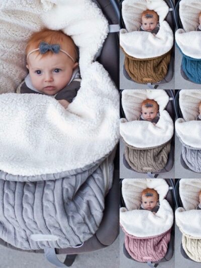 Bébé enveloppé dans une couverture tricotée en crochet. Disponible en plusieurs couleurs.