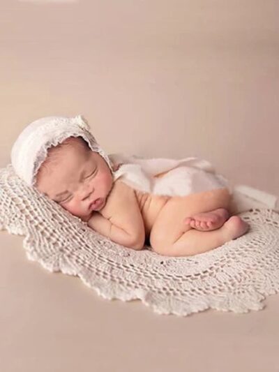Bébé photographié avec une couverture ronde crochetée.