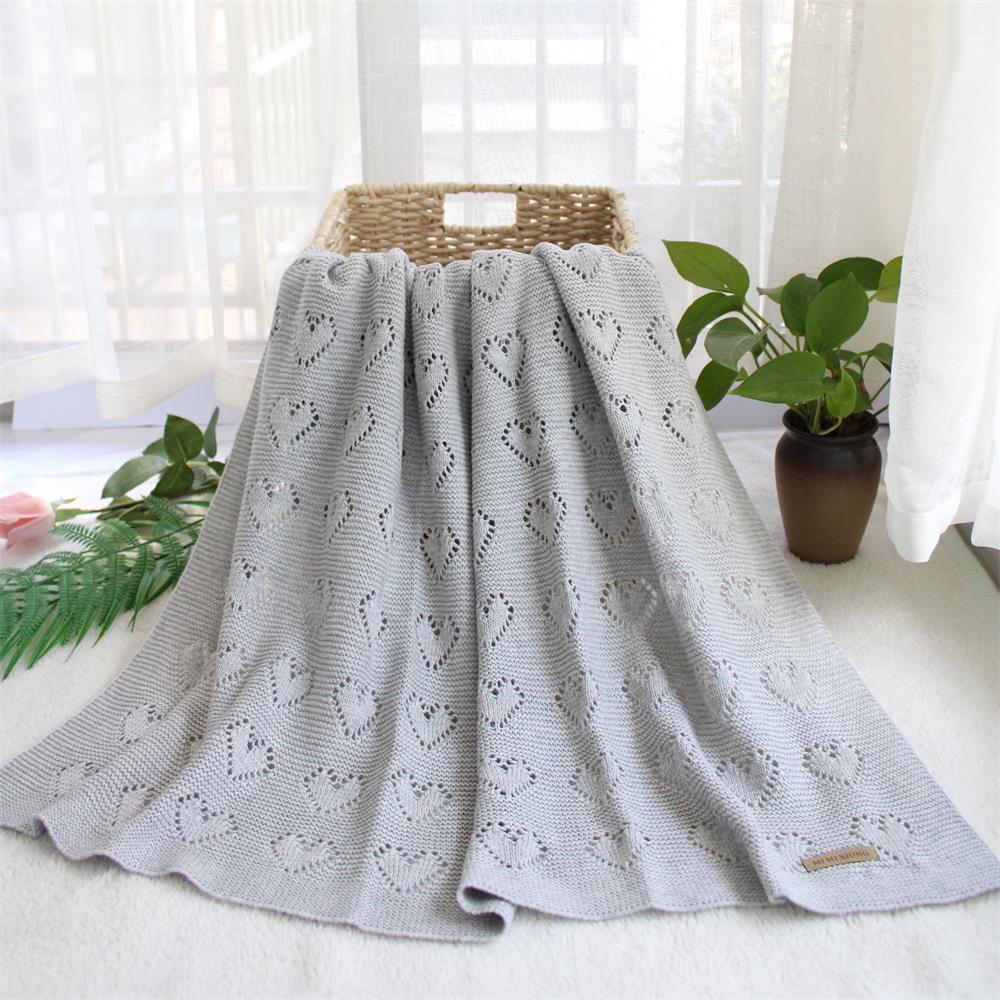 Couverture en forme de cœur tricotée en crochet de couleur grise.