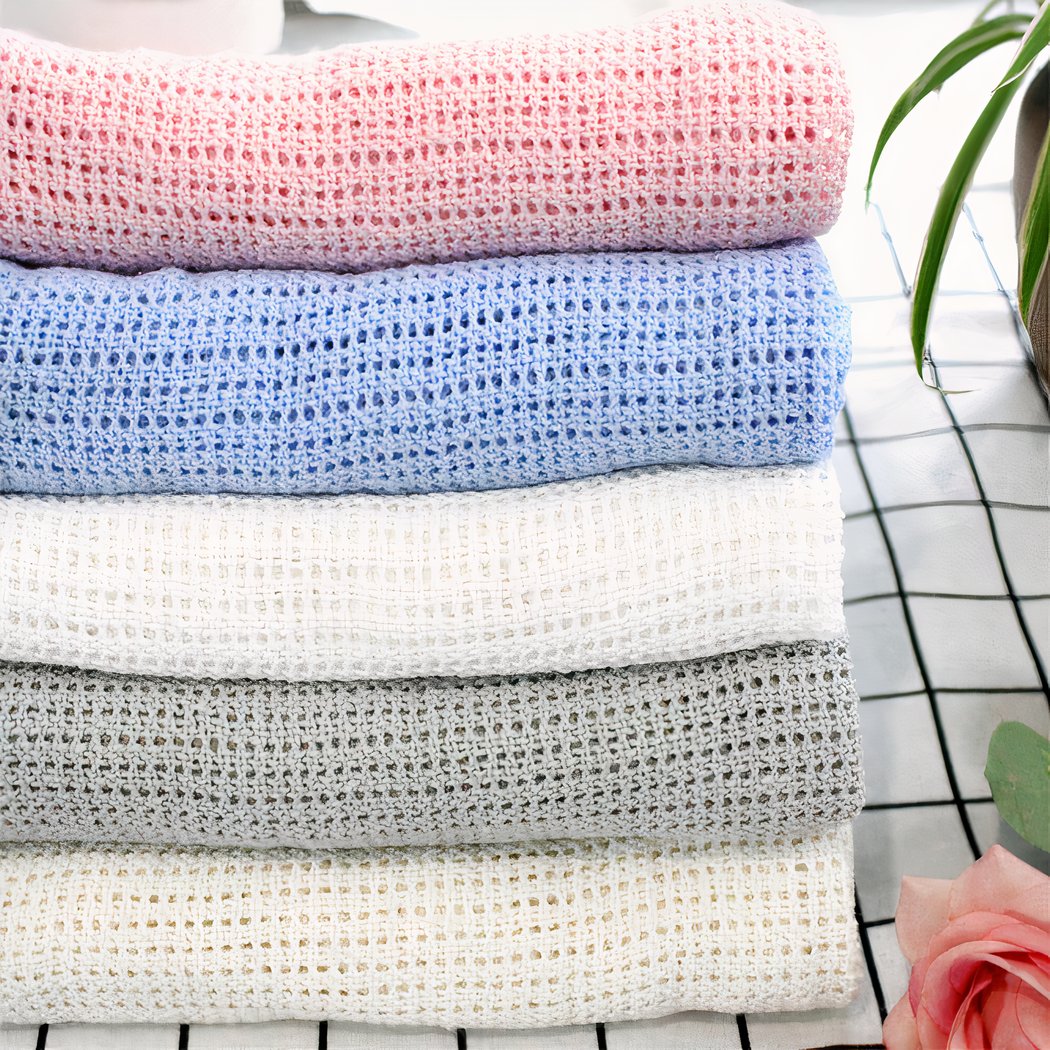 Couverture tricotée en crochet rose, bleu, blanc, gris.