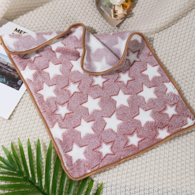On voit une couverture rose pour chien assez grande. Il y a des motifs d'étoiles blanches dessus. Le contour est rose foncé. Elle est joliment présentée comme sur un magazine de décoration.