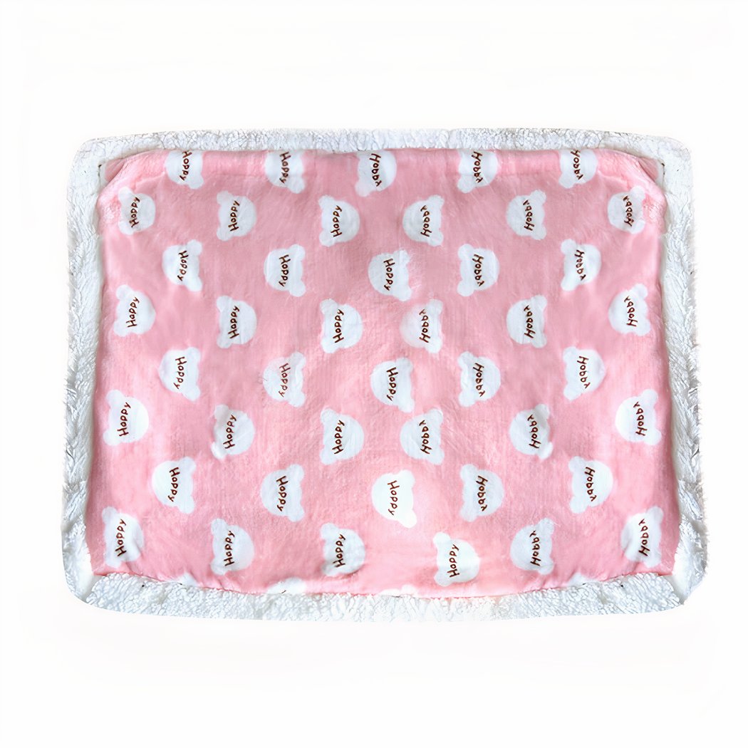On voit une couverture pour chien rose avec des motifs ourson blancs dans lesquels il y a écrit "Happy". La couverture est rectangle et présentée sur fond blanc.