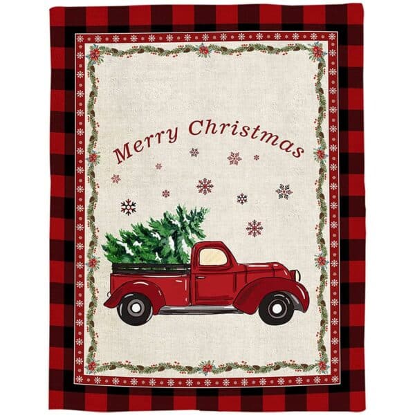 Plaid avec une voiture pickup rouge à l'ancienne, chargée d'un sapin de Noël, sur fond beige, avec des étoiles de noël au-dessus et Merry chrismas écrit encore au-dessus. Les bordures du plaid forment un cadre avec des carreaux noir et rouge, et des genres de guirlandes à l'intérieur.